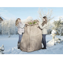 Zwei Personen verpacken Pflanzen in einen Winterschutzsack im verschneiten Garten.
