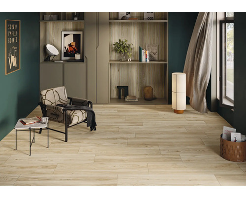 Wohnzimmer mit Holzoptikfliesen, Sessel und Regalsystem