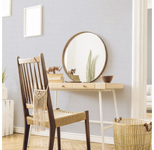 Dekorative Szene mit einem Schreibtisch, Stuhl, Spiegel und Accessoires in einem hellen Raum.