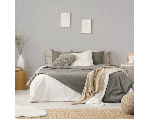 Schlafzimmer mit Bett, Nachttisch und gemusterter Tapete