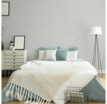 Schlafzimmer mit Bett, Nachttisch und Stehlampe