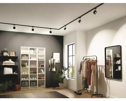 Modernes Ankleidezimmer mit flexibler Schienenbeleuchtung, Regalsystem und Kleiderständer.