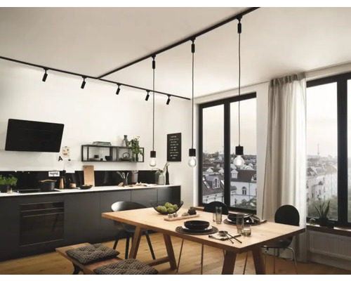 Moderne Küche mit linearem Schienensystem und Pendelleuchten über einem Holztisch.