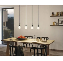 Esszimmer mit Holztisch, schwarzen Stühlen und vier Pendelleuchten