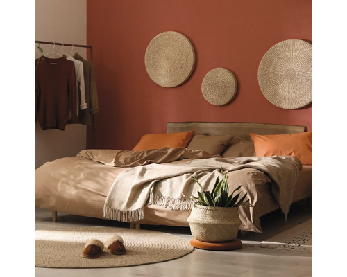 Schlafzimmer mit Bett, Wanddekorationen und Pflanzen