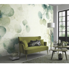 Wohnzimmer mit einer grünen Couch und einer Wandtapete mit Eukalyptus-Motiv