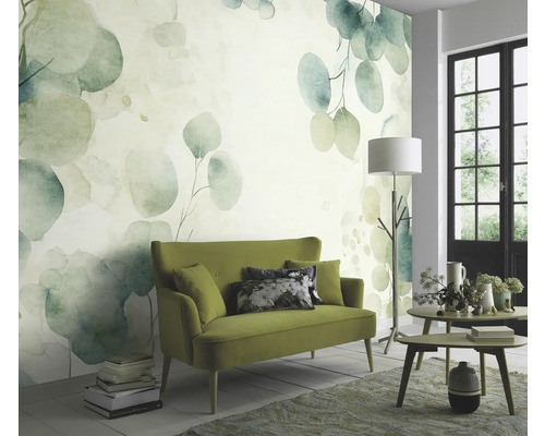 Wohnzimmer mit einer grünen Couch und einer Wandtapete mit Eukalyptus-Motiv