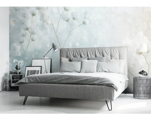 Schlafzimmer mit Bett, Nachttisch und floraler Tapete