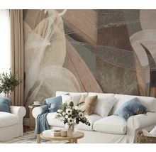 Wohnzimmer mit abstraktem Blättermuster an der Wand hinter einem weissen Sofa.