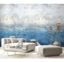 Wohnzimmer mit gemusterter Tapete, Sofa, Hocker, Tisch und Dekoration