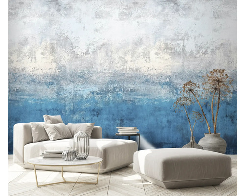 Wohnzimmer mit gemusterter Tapete, Sofa, Hocker, Tisch und Dekoration