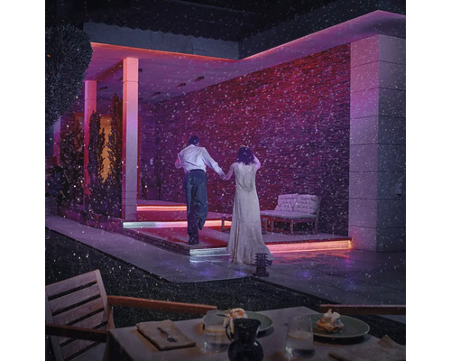 Beleuchtete Terrasse mit Paar im Schnee, stilvolles Ambiente für Outdoor-Bereiche