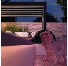 Gartenambiente mit Pergola, Lounge-Möbeln und Holzterrasse bei Dämmerung