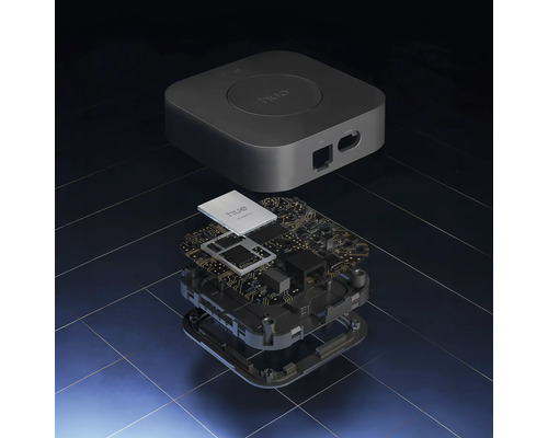 Explosionsdarstellung einer Philips Hue Bridge mit Gehäuse und interner Platine samt elektronischen Bauteilen.