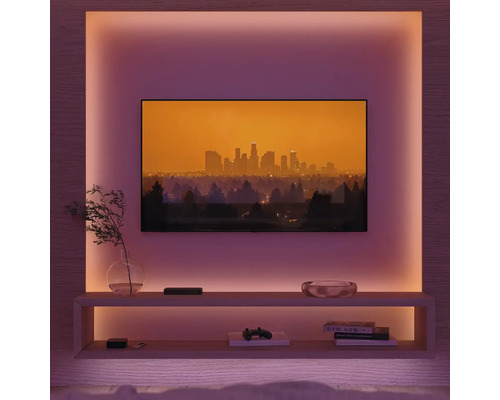 Wohnzimmer mit Fernseher, Regalen und indirekter Beleuchtung für eine gemütliche Atmosphäre