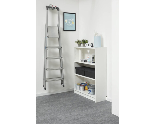 Silberne Aluminium-Stufenleiter an einer Wandhalterung in einem hellen, organisierten Raum neben einem weißen Regal.