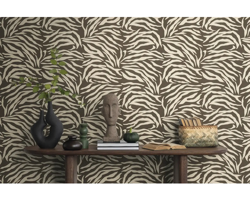 Raumansicht mit brauner Tapete im Zebramuster, dekoriert mit Vasen, Büchern und Dekorationen auf einem Holztisch.