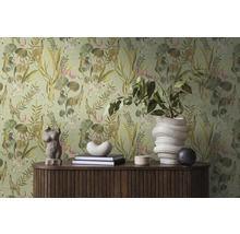 Szene mit einer Kommode vor einer grünen Dschungeltapete mit Tieren und Pflanzen