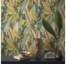 Nahaufnahme einer Wand mit Blättermuster-Tapete und dekorativen Gegenständen auf einem Tisch.