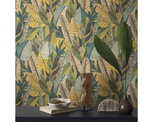 Nahaufnahme einer Wand mit Blättermuster-Tapete und dekorativen Gegenständen auf einem Tisch.