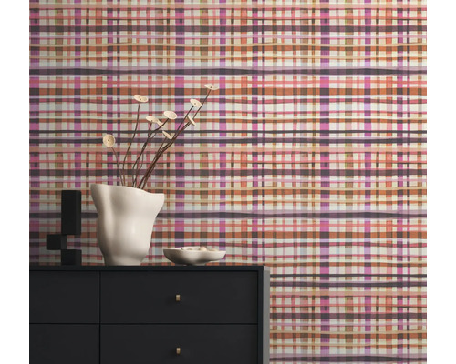 Szene mit einer Kommode und einer gemusterten Tapete im Hintergrund