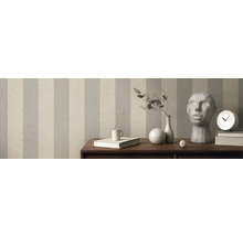 Zimmer mit gestreifter Tapete, Tisch mit Dekorationen wie Vase, Uhr und Skulptur