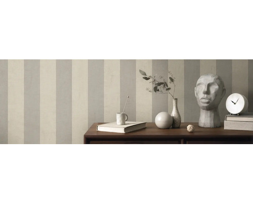 Zimmer mit gestreifter Tapete, Tisch mit Dekorationen wie Vase, Uhr und Skulptur