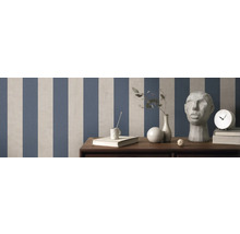 Raum mit gestreifter Tapete, Dekorationen und Möbeln auf Holzoberfläche.