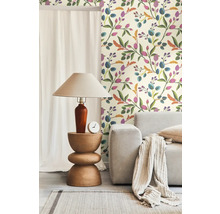 Einrichtungsidee mit einer Wandtapete mit Blumenmuster, einem Holztisch, einer Lampe und einem hellen Sofa