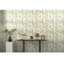 Helles Zimmer mit Blättertapete und Dekorationen auf einem Holztisch.