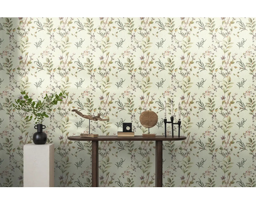 Helles Zimmer mit Blättertapete und Dekorationen auf einem Holztisch.