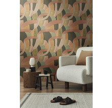 Wohnzimmer mit gemusterter Tapete, Sessel und Dekorationen auf Beistelltischen