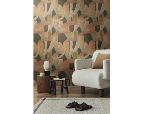 Wohnzimmer mit gemusterter Tapete, Sessel und Dekorationen auf Beistelltischen