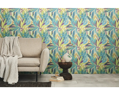 Raumansicht mit gemusterter Tapete mit floralem Blattmotiv, Sofa, Beistelltisch und Dekoration.