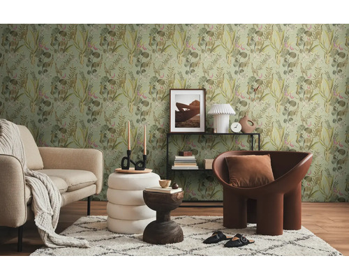 Wohnzimmer mit Sofa, Sessel, Teppich und Deko vor einer Wand mit Dschungeltapete