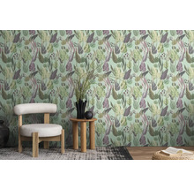 Ein Zimmer mit einer gemusterten Tapete mit Blättern, einem Stuhl und einem Beistelltisch.