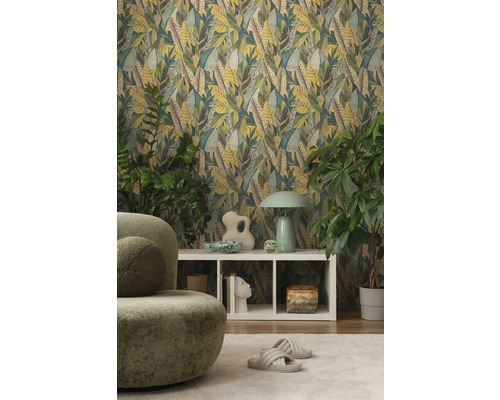 Wohnzimmer mit Blättertapete, grünem Sessel und weißem Regal