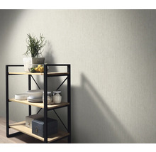 Szene mit gemusterter Tapete und einem Regal mit Dekorationsartikeln.