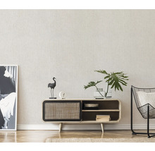 Wohnzimmer mit Kommode, Dekorationen, Pflanze und Sessel.