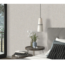 Schlafzimmer mit gemusterter Tapete, Nachttisch und Bett