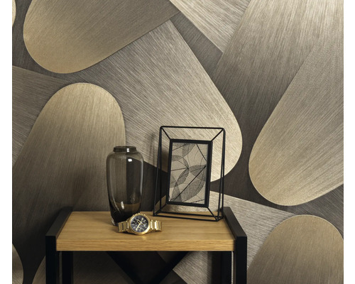 Dekorative Tapete mit geometrischem Muster hinter einem Tisch mit Blumenvase, Fotorahmen und Armbanduhr