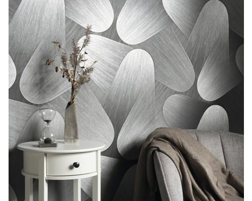 Szene mit einer Tapete mit abstraktem Muster, einem Beistelltisch mit Dekoration und einem Sessel