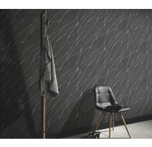 Wohnraum mit gemusterter Tapete, Stuhl und Garderobe