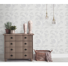 Wohnraum mit gemusterter Tapete, Kommode, Dekoration und Beleuchtung