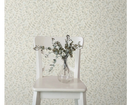 Dekorative Tapete mit Blattmuster, kombiniert mit einem Stuhl und einer Vase mit Zweigen für ein stilvolles Raumambiente.