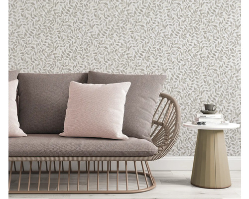Szene mit Sofa, Kissen, Beistelltisch und einer Tapete mit Blattmuster