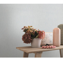 Nahaufnahme einer strukturierten Tapete mit Dekorationsgegenständen auf einem Holztisch