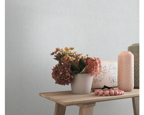 Nahaufnahme einer strukturierten Tapete mit Dekorationsgegenständen auf einem Holztisch