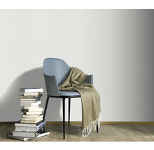 Dekoratives Ambiente mit Stuhl, Decke und Bücherstapel