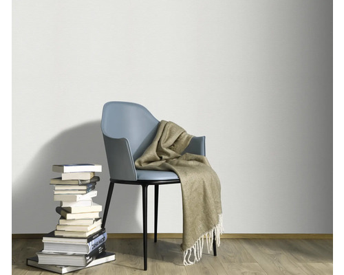 Dekoratives Ambiente mit Stuhl, Decke und Bücherstapel